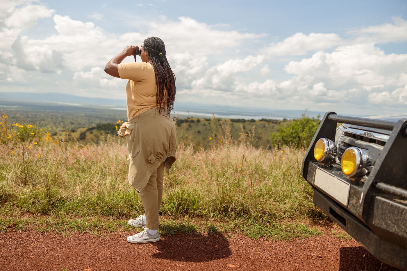 A guide scanning the plains with binoculars