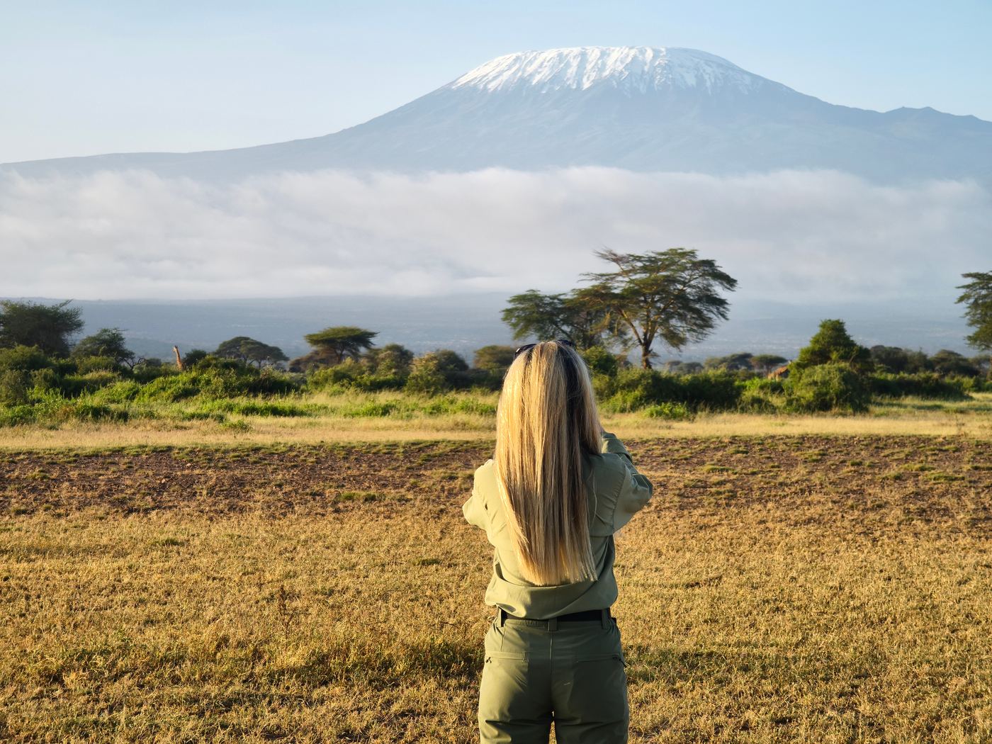 Walking safari below Kilimanjaro in long sleeves and a hat